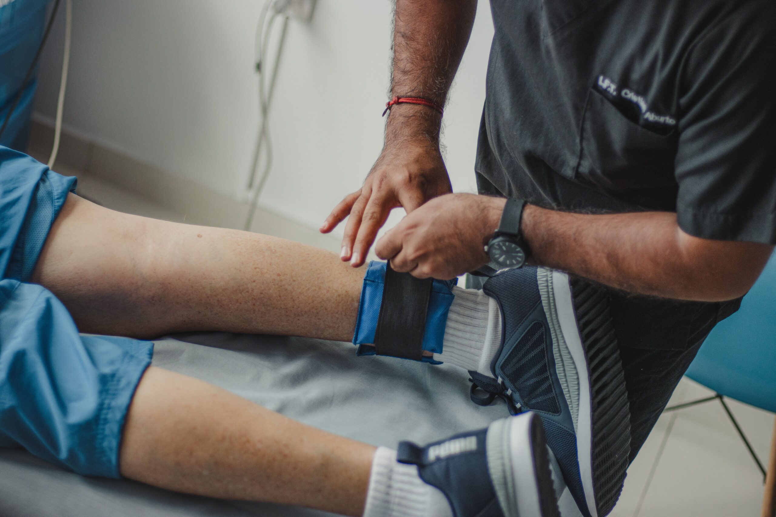 physiotherapist standing over patient lying down